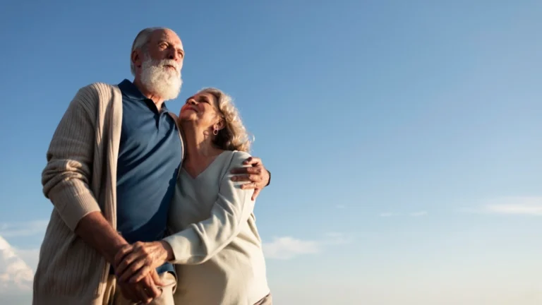 Stariji par zagrljen na otvorenom simbolizuje zdravo starenje i longevity, uz temu važnosti jetre i enzima jetre za očuvanje vitalnosti, energije i kvaliteta života